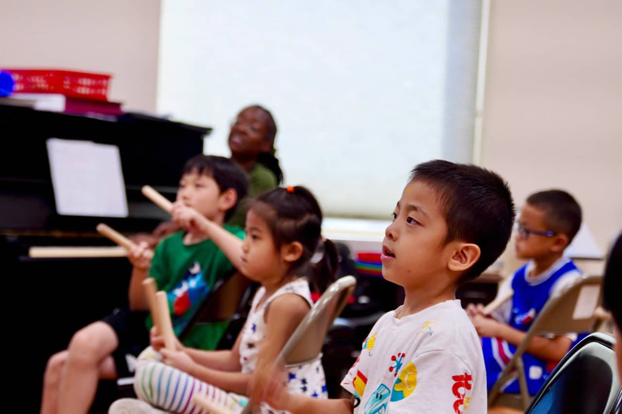 Children singing and playing instruments in a music class
